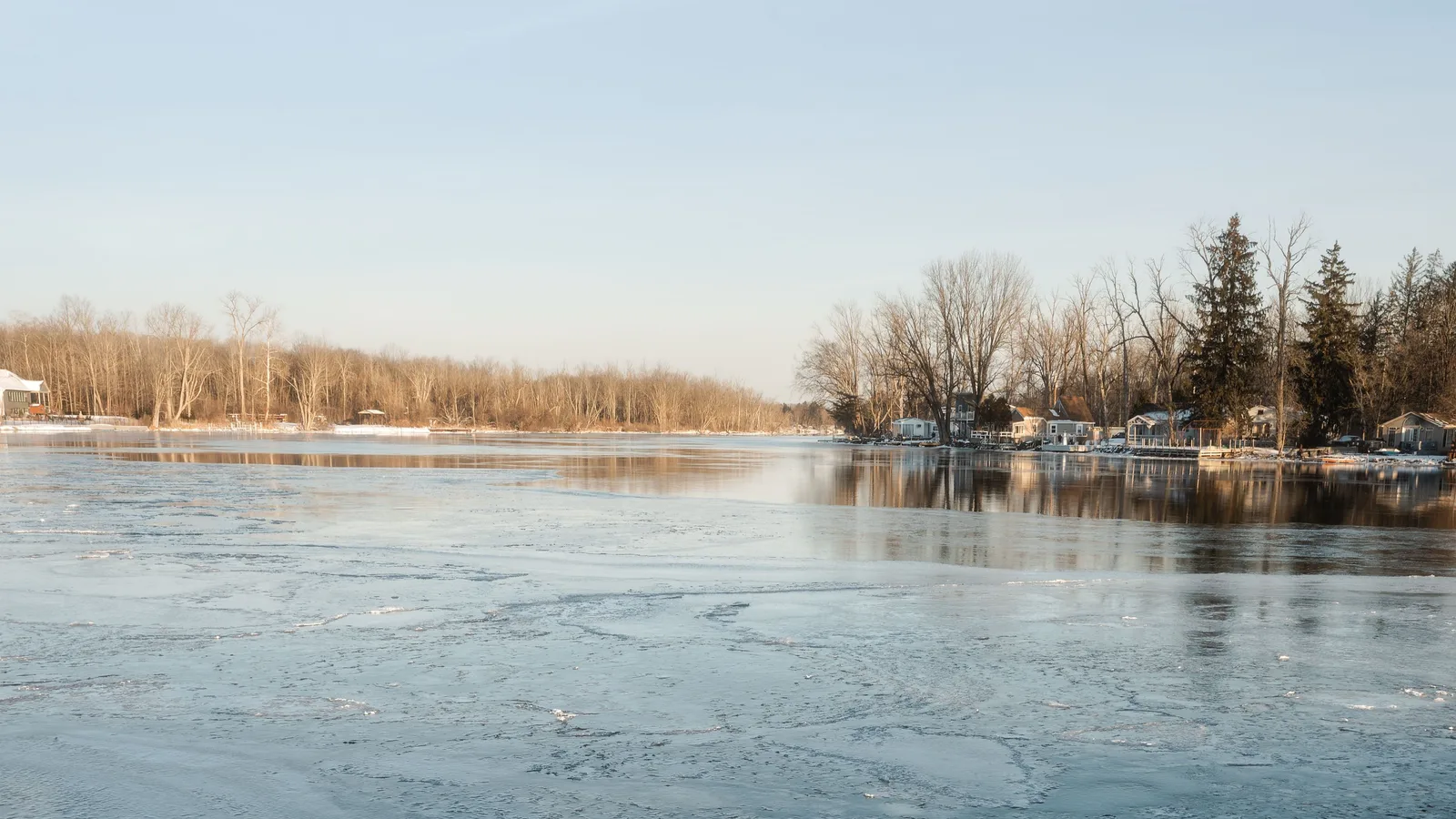 Zugefrorenes Gewässer im Winter mit geschlossener Eisdecke